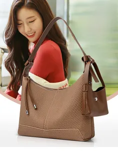 Detailed close-up of brown woven texture hobo bag with a matching leather mini pouch charm