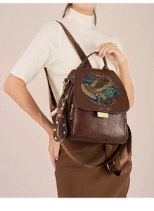 Detail of vintage brown leather backpack with elephant relief and golden buckle