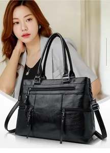 Close-up of black litchi pattern leather tote bag featuring functional front zipper pocket
