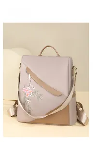 Close-up of floral embroidery on light purple waterproof nylon backpack with brown trim