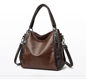 Close-up of caramel vintage tote bag with dual zippers and textured leather detail