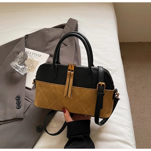 Detail of vintage bicolor quilted handbag with frosted leather texture and golden hardware