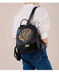 Detailed close-up of vintage black leather backpack featuring colorful elephant relief
