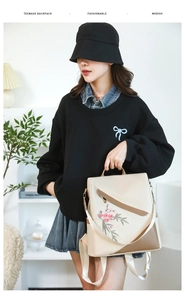 Fashionable floral embroidered backpack with beige and brown contrast worn by model
