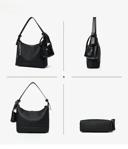 Detail of black textured hobo bag featuring adjustable strap and mini pouch attachment