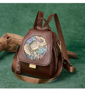 Detail of dark brown leather backpack featuring ethnic elephant patch and gold hardware