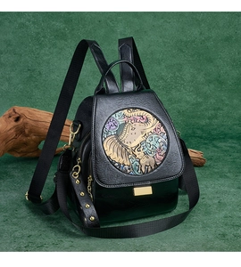 Macro detail of elephant relief embroidery and gold rivets on a black leather backpack