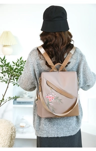 Detail of floral embroidery on taupe waterproof nylon backpack with crossbody straps