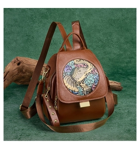 Close-up of brown vintage backpack with colored elephant relief and metal buckle