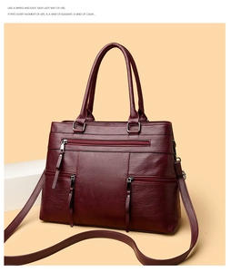 Close-up of wine red tote bag with lychee texture and fringe zipper details
