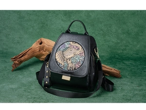 Detailed close-up of ethnic floral elephant relief on a black PU leather backpack