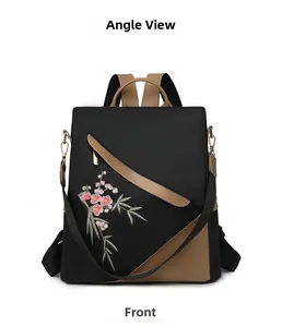 Front view of black nylon backpack with pink floral embroidery and brown leather trim