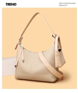 Detail view of woven texture and leather trim on a beige baguette shoulder bag with mini pouch