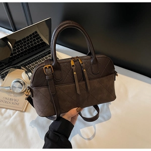 Detail of vintage quilted shoulder bag with dual handles and matte brown PU leather finish