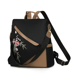 Detail showing high-density black nylon fabric and floral embroidery on the backpack