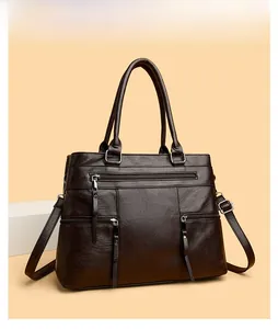 Detail of dark brown vintage tote bag with three front zippers and litchi grain texture