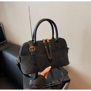Detail of black quilted shell bag with vintage gold hardware and dual zipper close