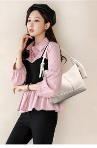 Asian model wearing minimalist off-white woven shoulder bag with a crescent shape