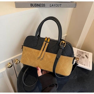 Detail of two-tone quilted shell bag with gold zippers and stitching details