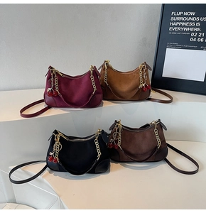 Group view of four suede crescent bags in burgundy and black with cherry charms