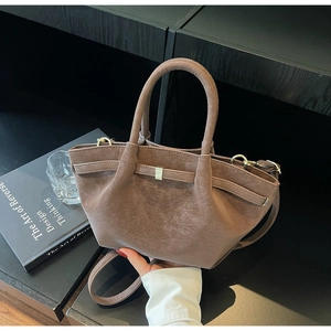 Close-up of vintage taupe tote bag showing matte pleated texture and gold hardware