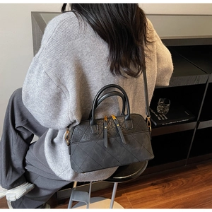 Détails du sac bandoulière vintage noir avec coutures en losanges et finitions dorées