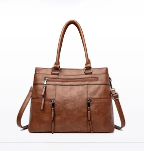 Detailed front view of brown vintage PU leather tote bag with silver zipper and strap