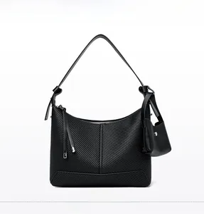 Detail of black textured leather bag featuring diagonal embossing and silver hardware