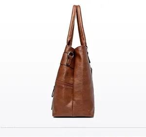 Detailed side view of brown PU leather tote bag featuring litchi texture and side zipper
