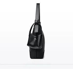 Side view of black faux leather baguette bag with textured embossing and mini coin pouch