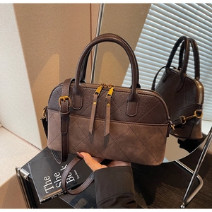 Détail du sac bandoulière marron foncé en patchwork avec surpiqûres en losange