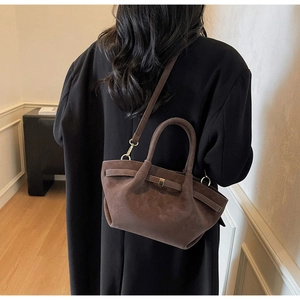 Model view of a dark brown suede crossbody bag with vintage matte finish and straps