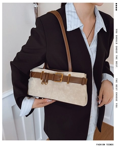 Détail du sac à bandoulière crème avec boucle de ceinture marron et garniture dorée