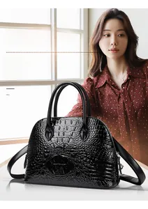 Detailed view of black crocodile pattern shell bag with silver hardware and glossy finish