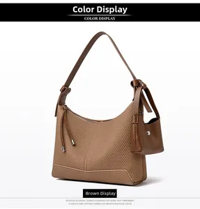 Detailed close-up of brown textured leather underarm bag with matching mini coin purse pouch