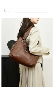 Détail d'un cabas en cuir marron à motif litchi avec pendentif feuille et rivets en métal