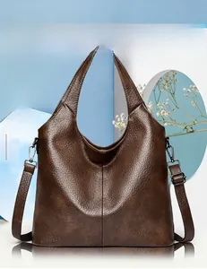 Detail of brown faux leather tote with adjustable metal buckles and versatile straps