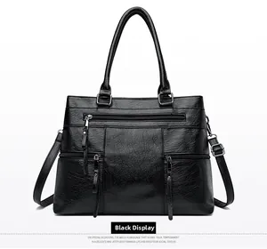 Detailed front view of black pebbled PU leather tote bag with three functional zippers