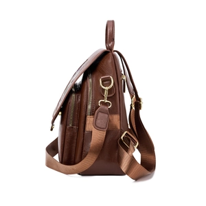 Brown leather backpack with multiple zippers and adjustable straps seen from a side view