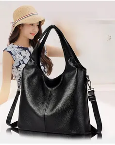 Model wearing a large black pebbled leather hobo bag with adjustable shoulder strap