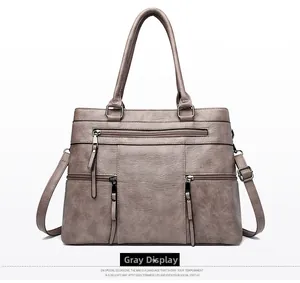 Detail view of grey retro tote bag with three front zipper pockets and top handles