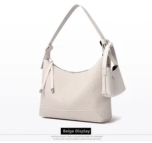 Detail of beige woven hobo bag with mini accessory pouch and adjustable shoulder strap