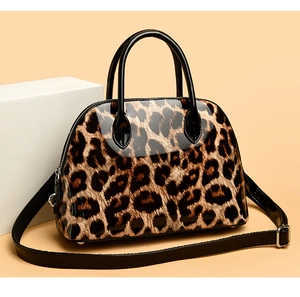 Close-up of gloss shell bag with leopard print pattern and metallic hardware details