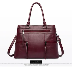 Close-up of wine red tote bag with pebble leather texture and metal zipper details