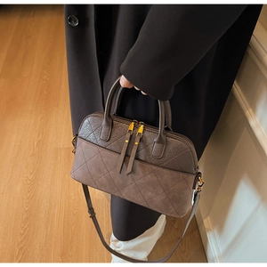 Détail du sac vintage matelassé avec fermetures dorées et bandoulière réglable