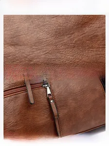 Detail of lychee pattern leather texture and silver zipper pull on a vintage tote bag