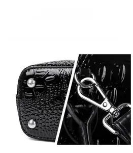 Close-up of silver metal feet and durable hardware on black crocodile pattern bag