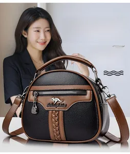 Close-up of black and brown cowhide handbag featuring woven strap details and logo