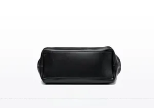 Detailed bottom view of black leather tote bag showing neat stitching and lychee texture