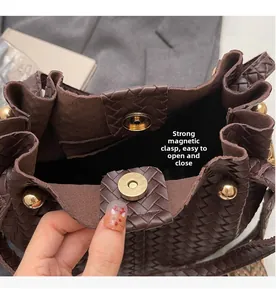 Close-up of woven bucket bag featuring secure magnetic clasp and golden hardware